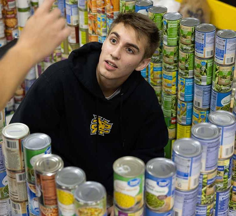 ksu student volunteering at food panrty sorting can goods